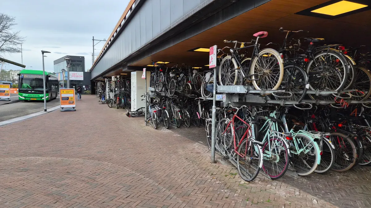 Double-decker bicycle parking with a nearby bus in The Hague, Netherlands.