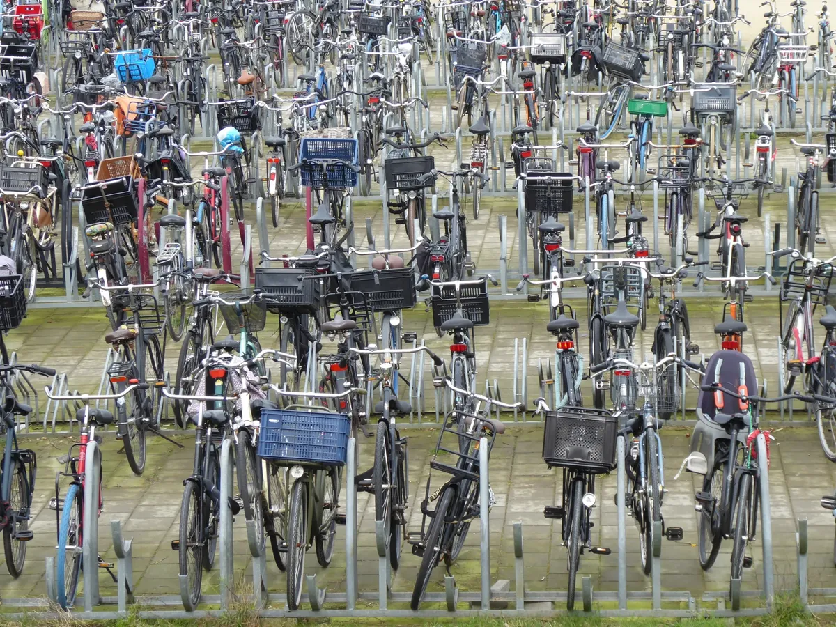 A crowded outdoor bicycle parking lot filled with numerous parked bicycles.