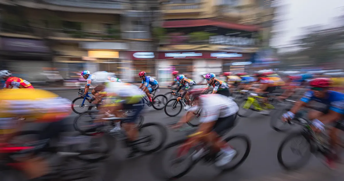 Vibrant urban bicycle race captured with motion blur emphasizing speed and competition.