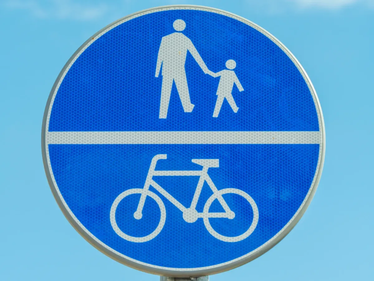 Blue road sign indicating shared pedestrian and bicycle path.