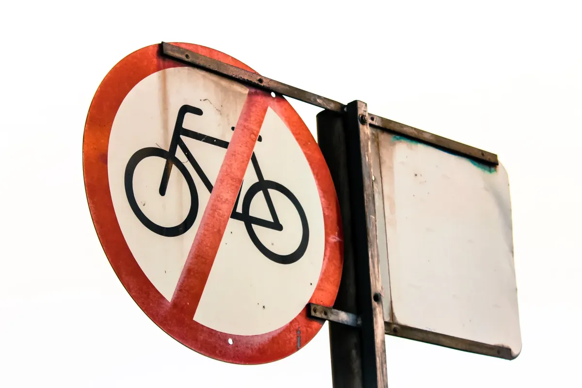 A close-up of a weathered 'No Bicycles Allowed' street sign, emphasizing traffic restrictions.