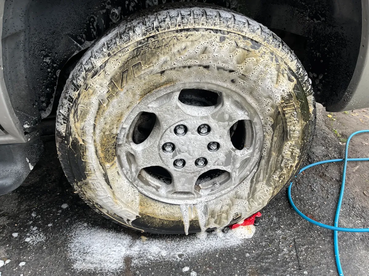 車のホイールが洗剤で洗われている様子を詳しく撮った写真。