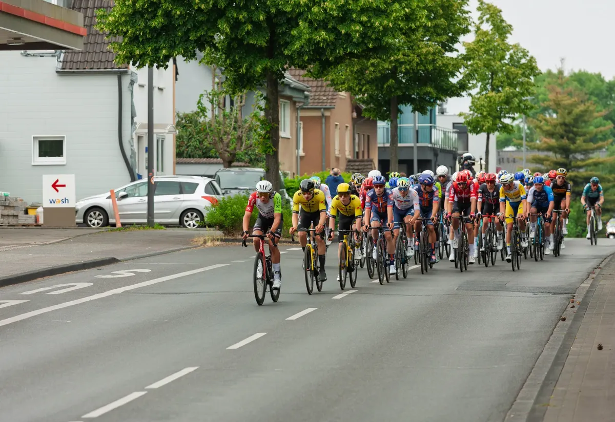 Cyclists in a high-speed competition racing through an urban area, showcasing athletic endurance and team strategies.